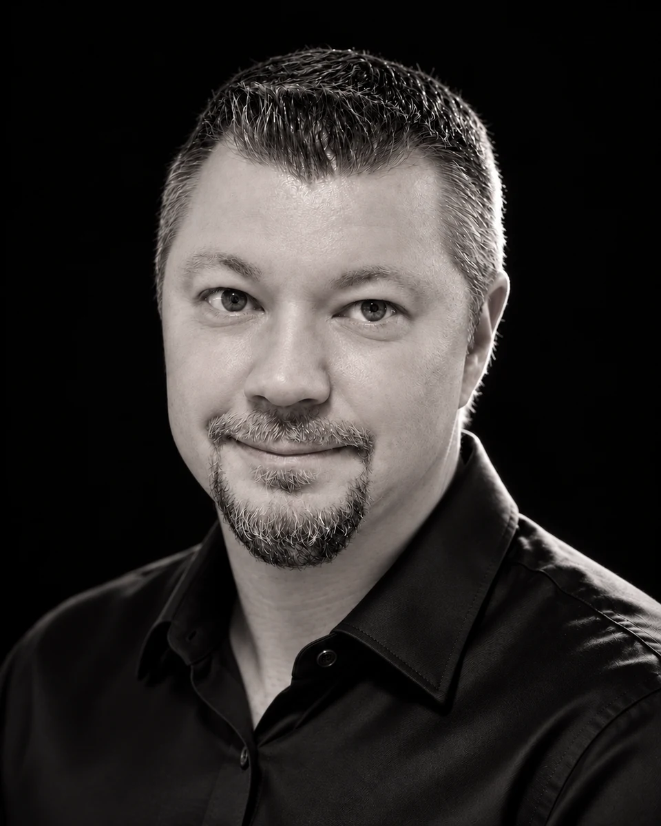 Marko Linturi mustassa kauluspaidassa, mustavalkoinen studiomuotokuva